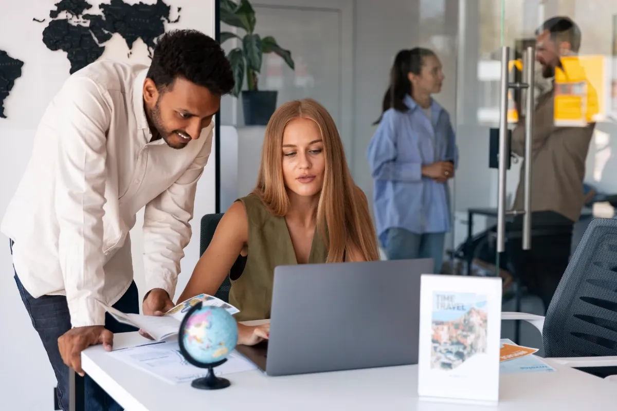 Creative team collaborating on a marketing plan around a laptop