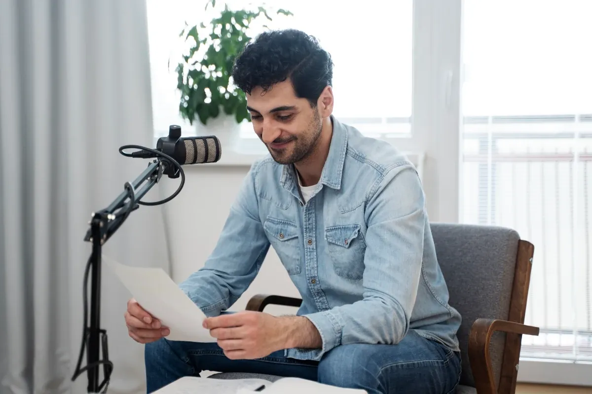Creator recording a podcast with a studio microphone while reading notes